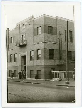 Snapshot of the facade of the Workmen's Circle with eight individuals standing at front door, 4848 Boulevard St. Laurent