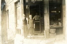 Portrait of unidentified man and woman outside of business