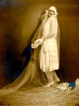 Mizzi Packer posed in wedding dress and veil next to bouquet